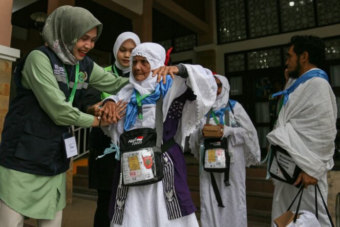 
					Petugas_membantu_jemaah_naik_ke_bus (MCH Aceh 2025)