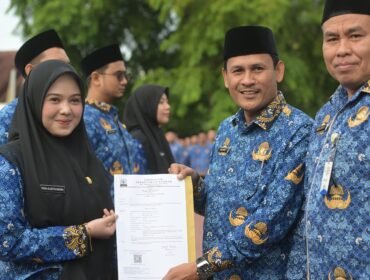 Banda Aceh - Asisten II Sekda Aceh, Zulkifli, mewakili Gubernur Aceh, menyerahkan Surat Keputusan (SK) Gubernur tentang Pengangkatan 618 Calon Aparatur Sipil Negara (CASN) Pemerintah Aceh Tahun 2024. Penyerahan SK dilakukan dalam sebuah upacara yang berlangsung di Halaman Kantor Gubernur Aceh, Selasa 17 Juni 2025.