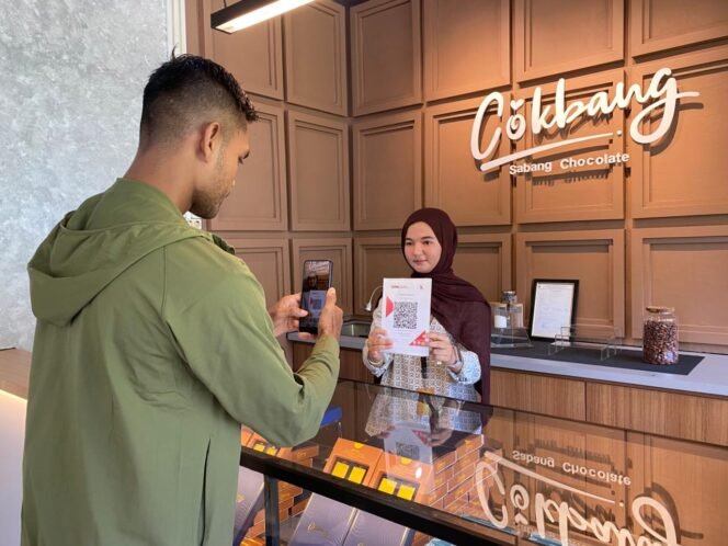 
					Seorang pelanggan melakukan pembayaran non-tunai menggunakan QRIS di gerai Cokbang Sabang Chocolate [Foto: M Fadhil]