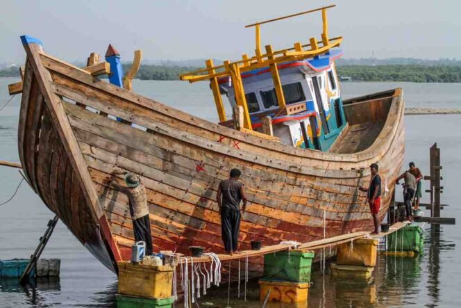 
					Pekerja menyelesaikan pembuatan kapal nelayan di pesisir kawasan Tempat Pendaratan Ikan Desa Pusong, Lhokseumawe, Aceh, Selasa (9/7/2019). 