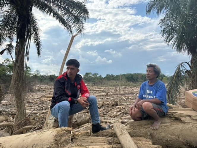 
					Relawan Badak-19, Alif Ramadhan, duduk bersama warga Aceh Tamiang di antara puing dan tumpukan kayu sisa banjir, mendengarkan langsung keluh-kesah dan kondisi masyarakat terdampak.