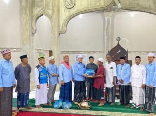 BANTUAN SEMBAKO: Sekretaris Umum DPD BKPRMI Aceh Timur, Tgk Ismuhadi, MSM, menyerahkan bantuan sembako ke Marbot Masjid Baitul Manan Matang Pineung Idi Cut, Tgk Muhammad Isa, dalam kunjungan Safari Ramadan di Gampong Matang Pineung, Kec. Darul Aman, Kab. Aceh Timur, Senin (2/3) malam. Foto Dok. Humas BKPRMI Aceh Timur