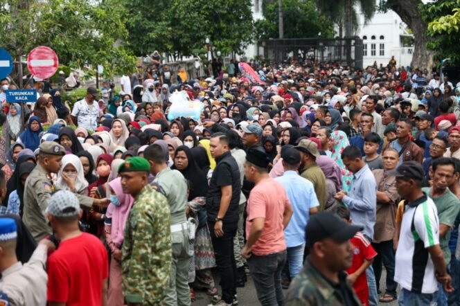 
					Gubernur Aceh, Muzakir Manaf atau Mualem, membagikan tunjangan hari raya (THR) kepada warga melalui timnya di Meuligoe Gubernur Aceh, Kota Banda Aceh, Jumat (20/3/2026) siang