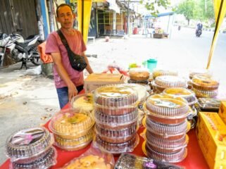 Hasan (48) pedagang berbagai jenis kue bolu di Pasar Lambaro, Kecamatan Ingin Jaya, Aceh Besar , Senin (23/03/2026). FOTO/MC ACEH BESAR