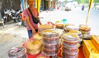Hasan (48) pedagang berbagai jenis kue bolu di Pasar Lambaro, Kecamatan Ingin Jaya, Aceh Besar , Senin (23/03/2026). FOTO/MC ACEH BESAR