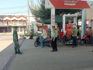 Petugas sedang melakukan pelayanan ketertiban di SPBU Aneuk Galong, Sukamakmur, Senin (23/3/2026).
FOTO/MC ACEH BESAR