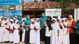 Bunda Guru Aceh Marlina Muzakir, didampingi Ketua Dharma Wanita Persatuan Aceh Malahayati, membagikan paket seragam sekolah dan paket olahan serba ikan kepada sisa-siswi SD Negeri Tanah Rata, Gampong Tanah Rata Kecamatan Peureulak, Rabu (15/4/2026).