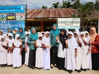 Bunda Guru Aceh Marlina Muzakir, didampingi Ketua Dharma Wanita Persatuan Aceh Malahayati, membagikan paket seragam sekolah dan paket olahan serba ikan kepada sisa-siswi SD Negeri Tanah Rata, Gampong Tanah Rata Kecamatan Peureulak, Rabu (15/4/2026).