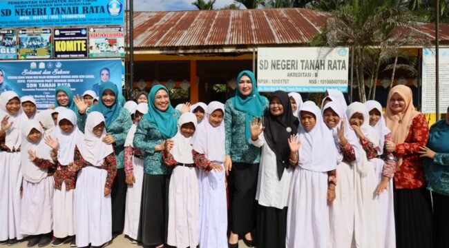 Bunda Guru Aceh Marlina Muzakir, didampingi Ketua Dharma Wanita Persatuan Aceh Malahayati, membagikan paket seragam sekolah dan paket olahan serba ikan kepada sisa-siswi SD Negeri Tanah Rata, Gampong Tanah Rata Kecamatan Peureulak, Rabu (15/4/2026).