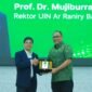 Rektor UIN Ar-Raniry Banda Aceh, Prof Mujiburrahman menyerahkan Cendera Mata kepada Komisaris Utama BSN Prof Bahrullah Akbar sebagai Narasumber pada Kuliah Umum yang berlangsung di Auditorium Prof Ali Hasjmy UIN Ar-Raniry Kopelma Darussalam Banda Aceh, Selasa (19/5/2026).