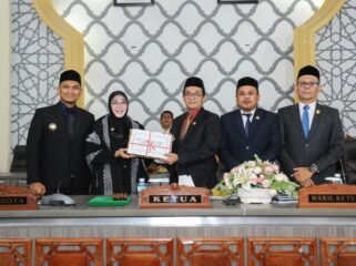 Wali Kota Banda Aceh, Illiza Sa’aduddin Djamal, saat menyerahkan Laporan Keterangan Pertanggungjawaban (LKPJ) Tahun Anggaran 2025 kepada DPRK Banda Aceh kepada Ketua DPRK Banda Aceh, Irwansyah ST, didampingi Wakil Ketua I Daniel Abdul Wahab, S.Pd., dan Wakil Ketua II, Dr. Musriadi Aswad, S.Pd., M.Pd dalam rapat paripurna di Gedung DPRK Banda Aceh, Senin (13/7/2026).