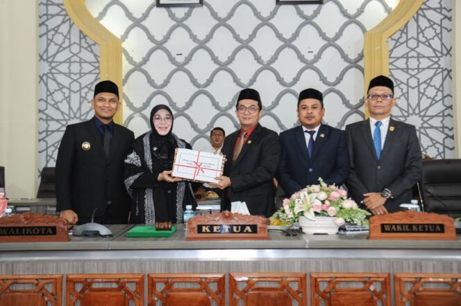 
					Wali Kota Banda Aceh, Illiza Sa’aduddin Djamal, saat menyerahkan Laporan Keterangan Pertanggungjawaban (LKPJ) Tahun Anggaran 2025 kepada DPRK Banda Aceh kepada Ketua DPRK Banda Aceh, Irwansyah ST, didampingi Wakil Ketua I Daniel Abdul Wahab, S.Pd., dan Wakil Ketua II, Dr. Musriadi Aswad, S.Pd., M.Pd dalam rapat paripurna di Gedung DPRK Banda Aceh, Senin (13/7/2026).