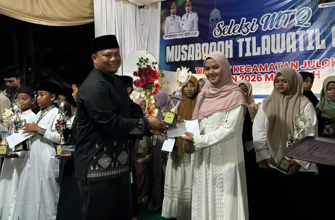 
					Camat Julol, H. Muhammad Ishak, menyerahkan tropi dalam penutupan MTQ X Julok di Komplek Kantor Camat Julol di Kuta Binjei, Aceh Timur, Kamis (24/9) malam.